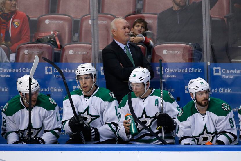 Dallas Stars head coach Lindy Ruff, rear, looks on during the second period of an NHL hockey...