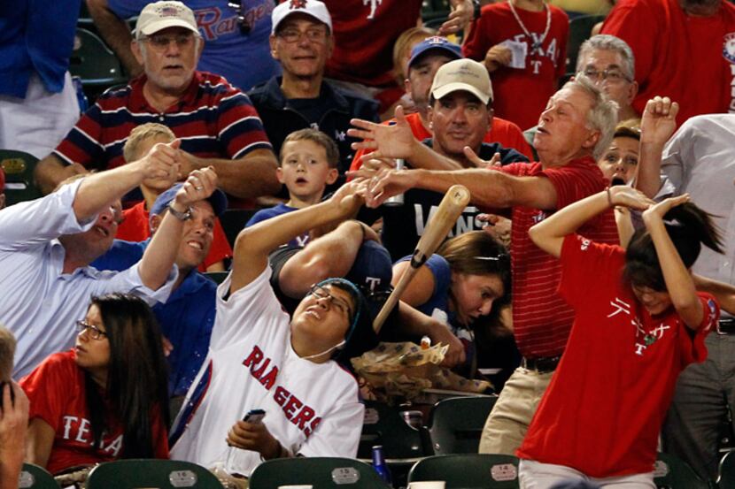 Fans duck from a bat thrown by Houston Astros left fielder J.D. Martinez (14) in a game...