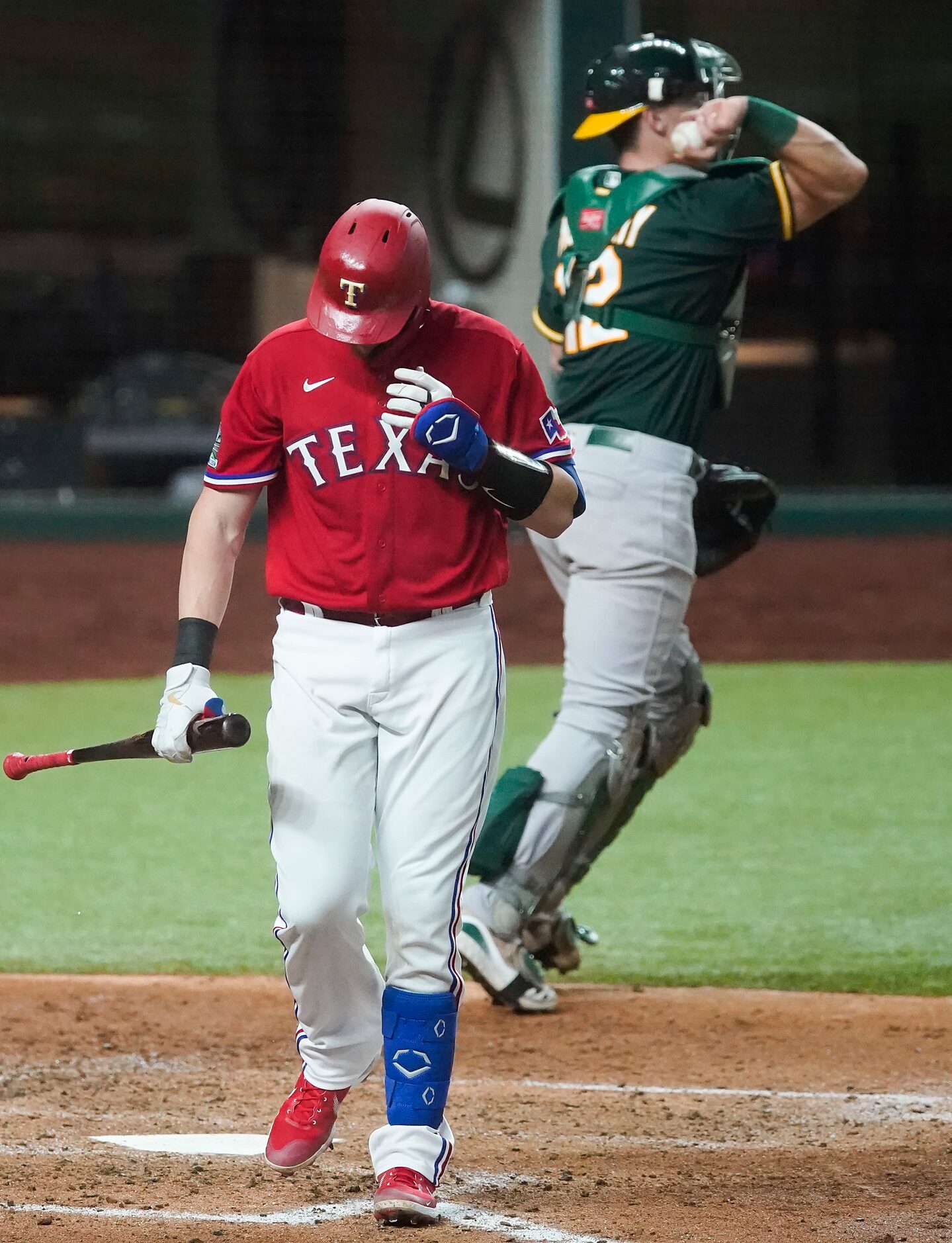 Texas Rangers catcher Sam Huff heads for the dugout after striking out to end the second...