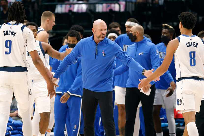 Dallas Mavericks head coach Jason Kidd slaps hands with his center Moses Brown (9) and guard...