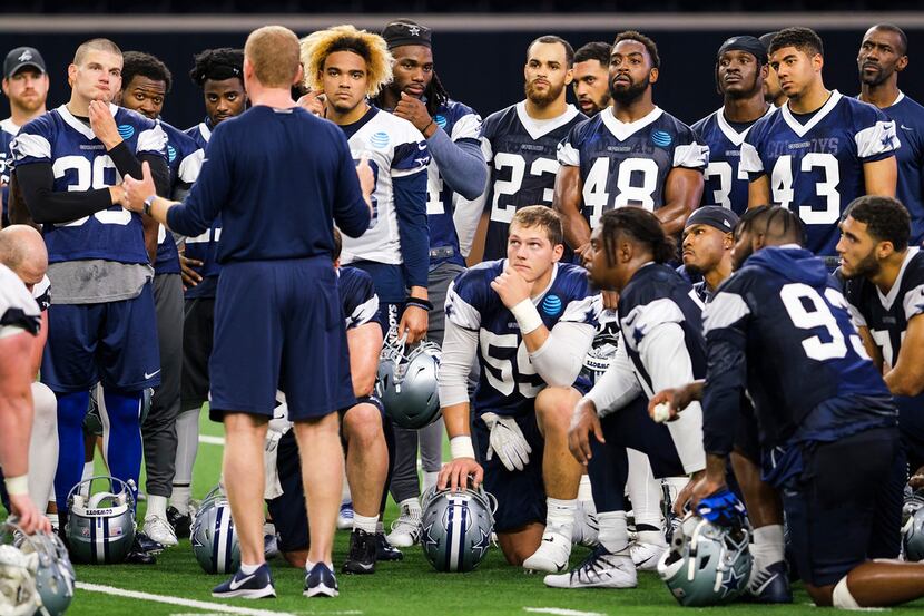 Dallas Cowboys players gather around head coach Jason Garrett during a team OTA practice at...