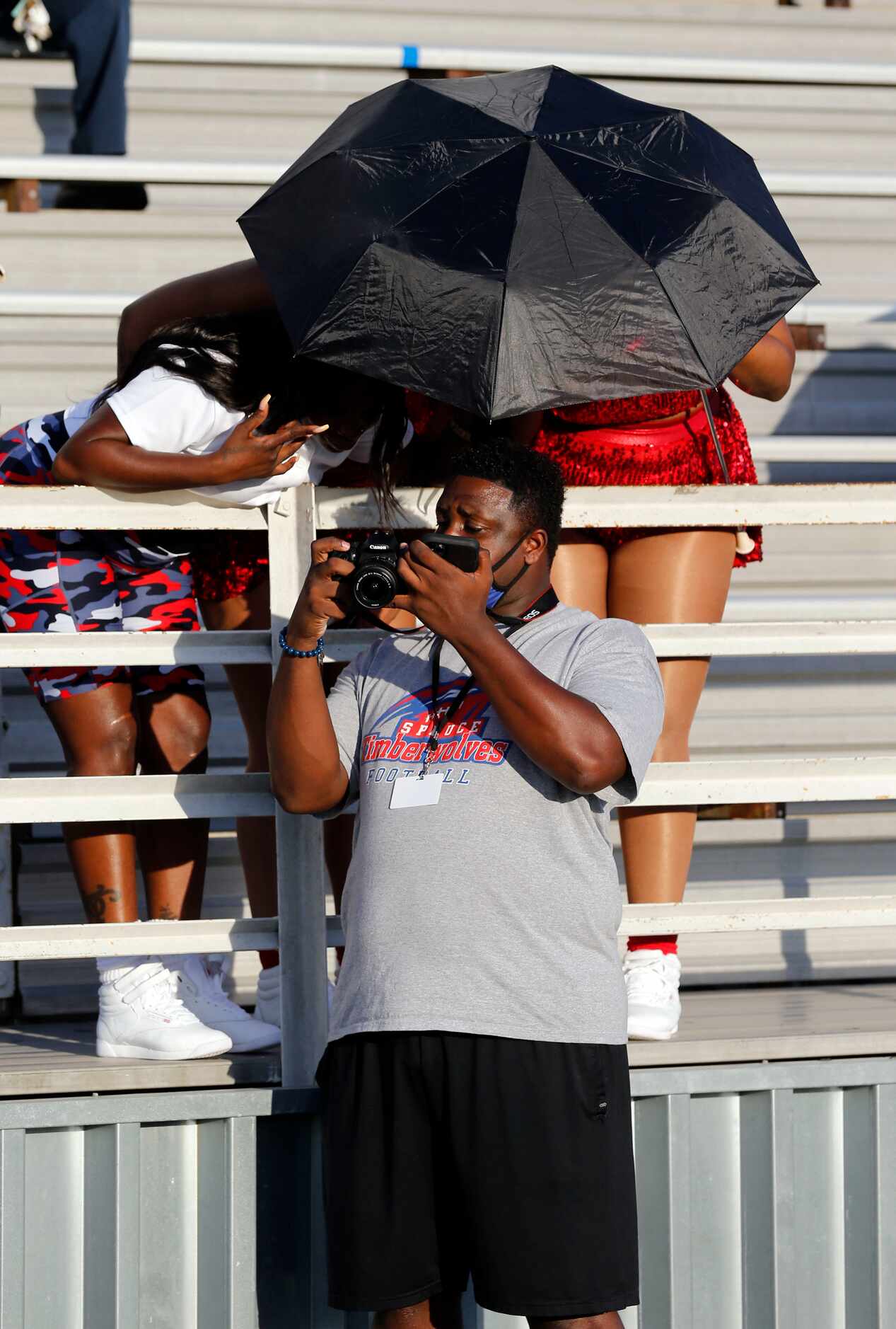 A photographer shows a photo to two women under umbrellas before the first half of the...