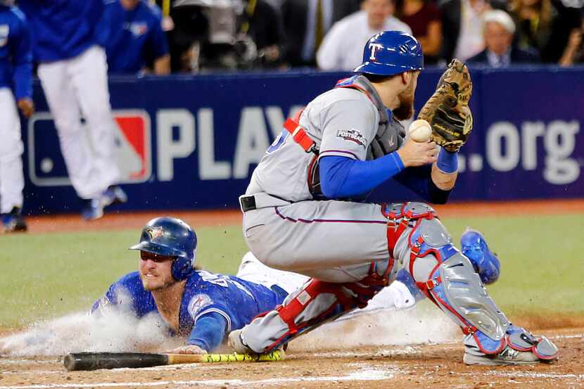 Toronto Blue Jays Josh Donaldson (20) slides into home to win the game in extra innings as...