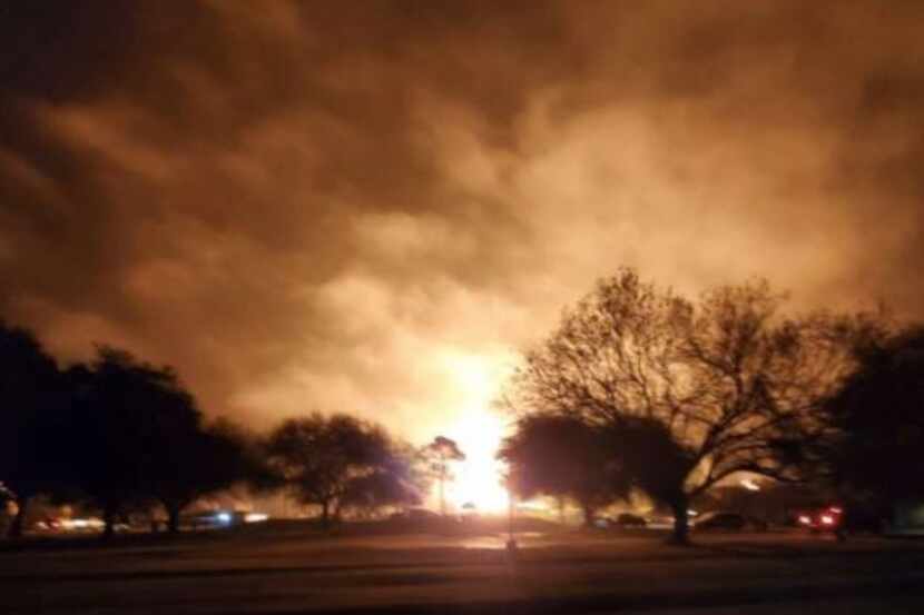 Flames are visible as the sky glows orange where a chemical plant exploded in Port Neches on...