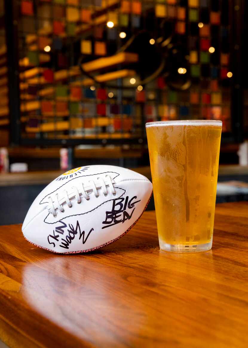 A ball signed by Rollertown Beerworks owners Ben Rogers and Jeff "Skin" Wade is photographed...