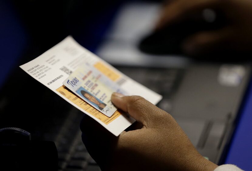 In this 2014 file photo, an election official checks a voter's photo identification at an...