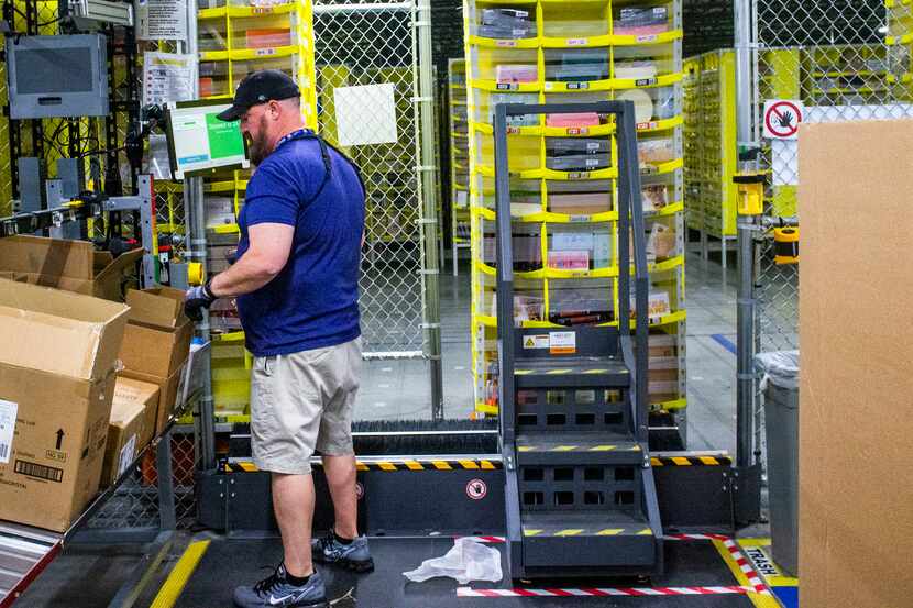 Amazon employee organized packages at an Amazon fulfillment center in Bethel Road in Grapevine.