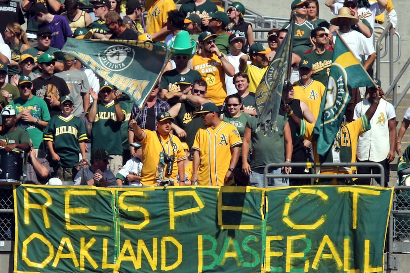 The A's fans display their sentiments with a sign on the left field fence during the Texas...