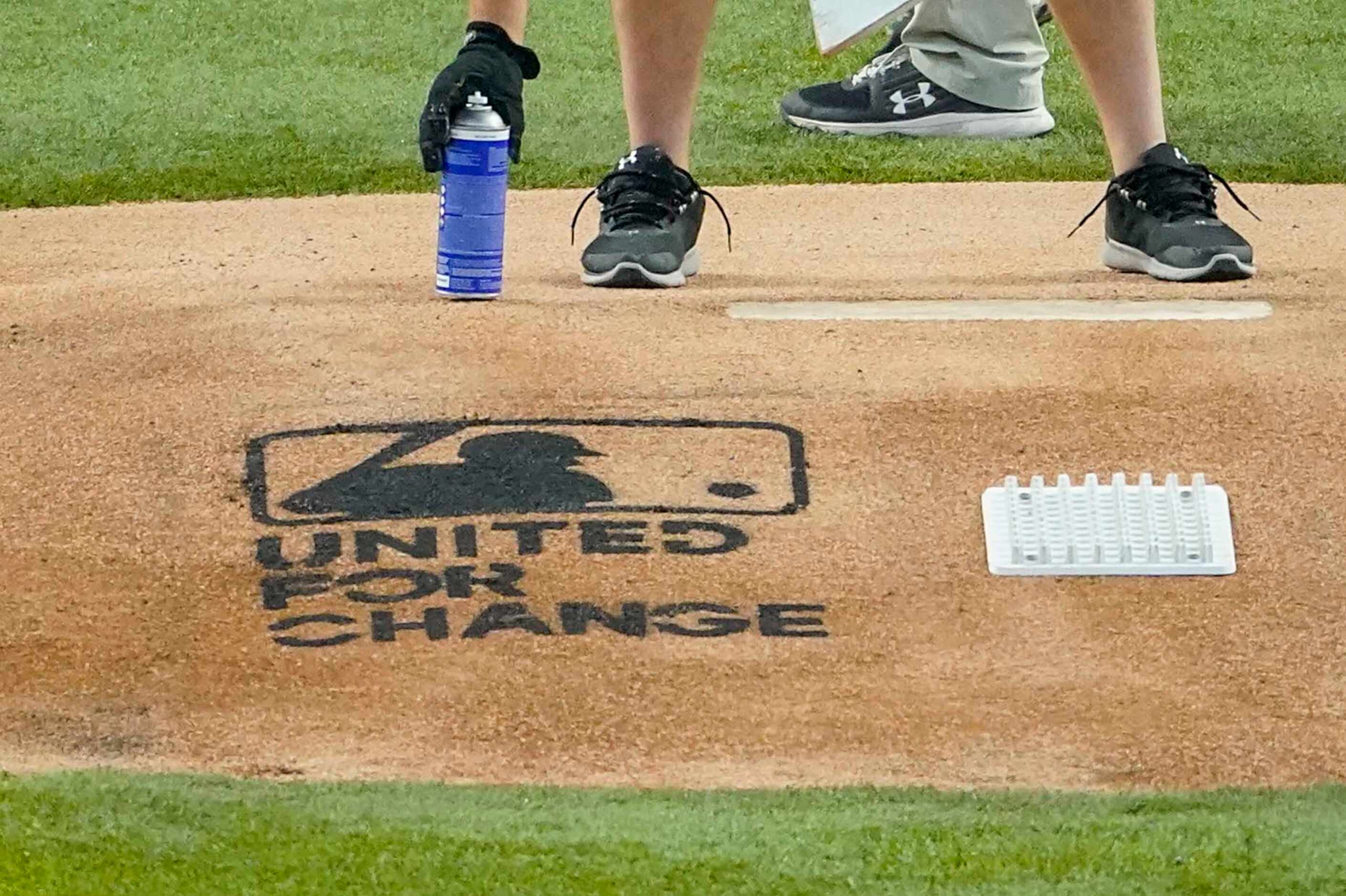 Grounds keepers spray paint ÒUnited For ChangeÓ on the pitchers mound before a baseball game...