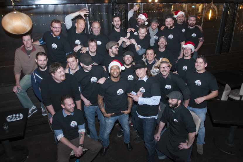 Area bartenders surround Bryan Townsend pose for a group photo before the start of a...