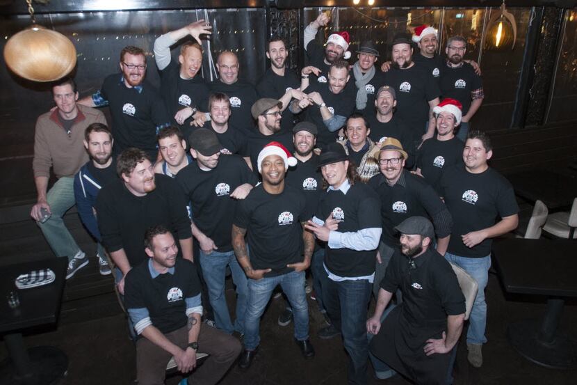 Area bartenders surround Bryan Townsend pose for a group photo before the start of a...