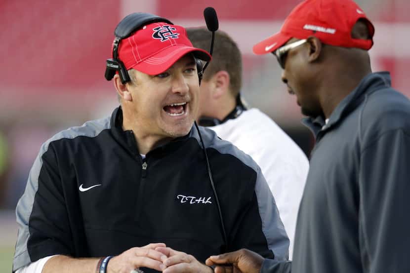 (TXHSFB) Cedar Hill coach Joey McGuire, left, talks with an assistant during a break in the...