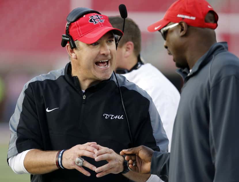 (TXHSFB) Cedar Hill coach Joey McGuire, left, talks with an assistant during a break in the...