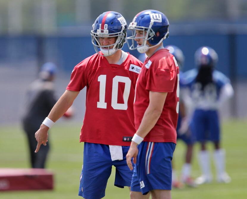 New York Giants quarterbacks Eli Manning, left, and Davis Webb talk during NFL football...