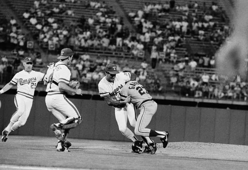 Detroit Tigers' first baseman Barbaro Garbey (27) wrestles with Texas Rangers' pitcher Mike...
