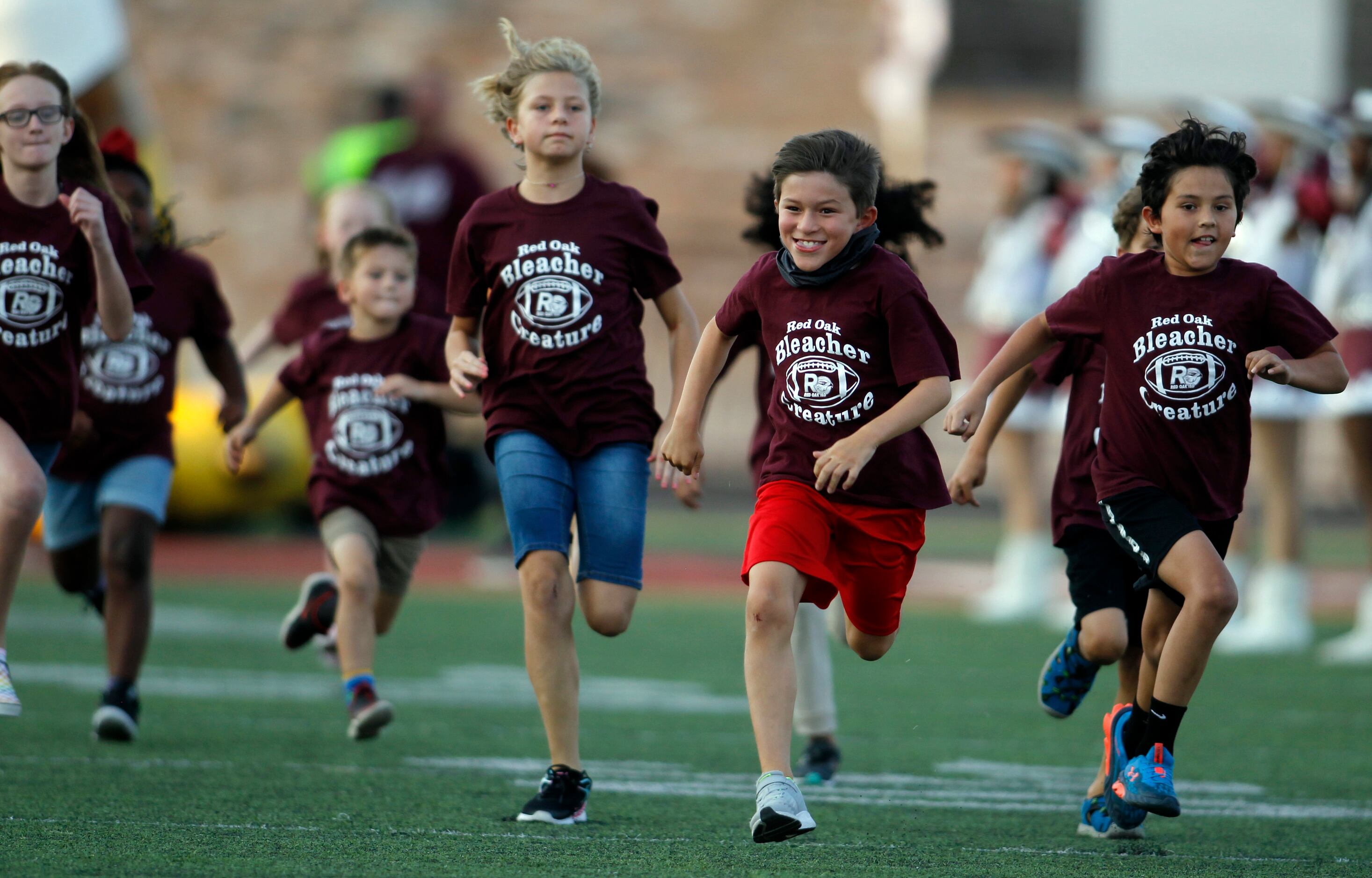 Members of the Red oak Bleacher Creatures bolt from the team inflatable prior to the start...