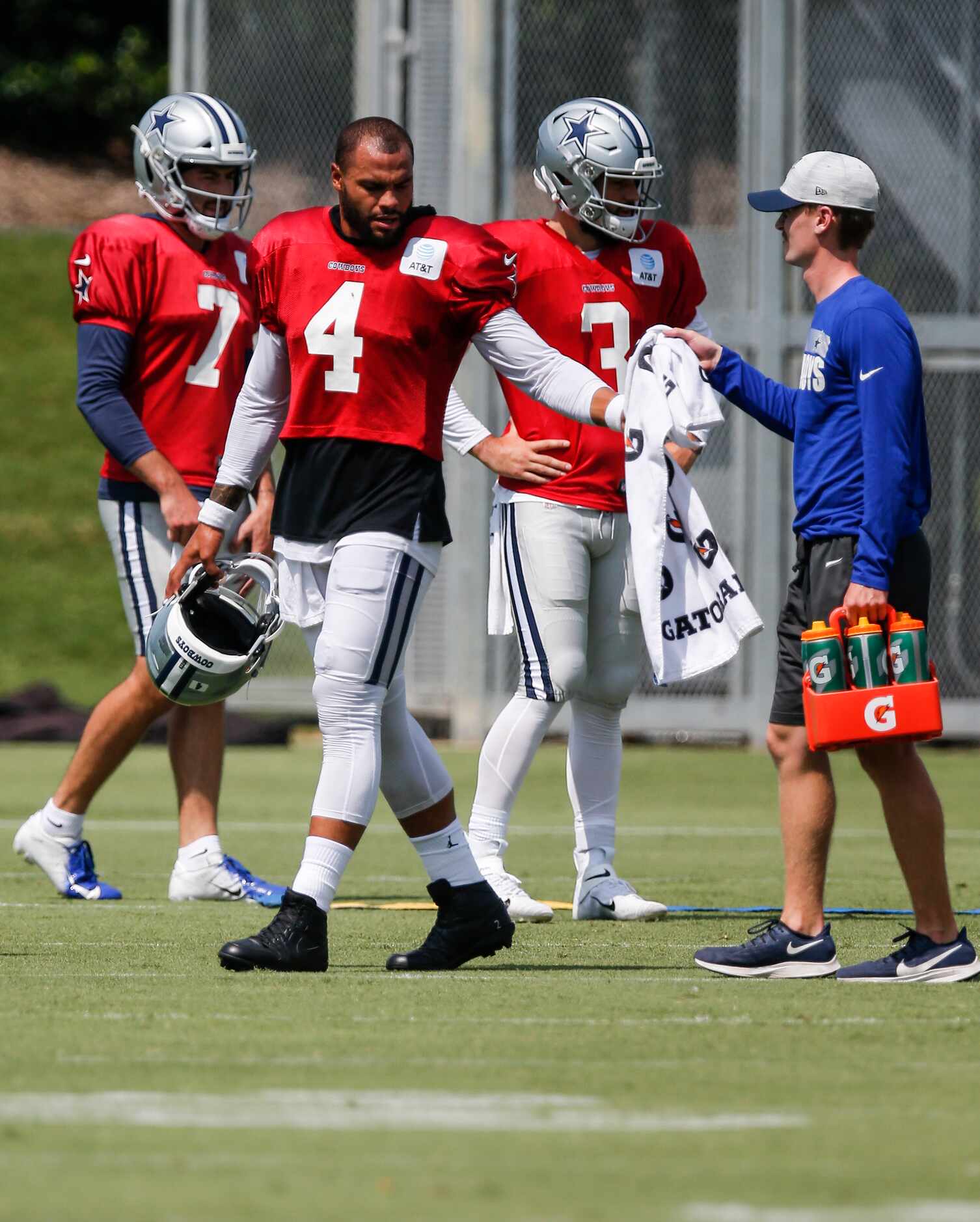 Dallas Cowboys quarterback Dak Prescott (4) takes a towel from a trainer during practice at...