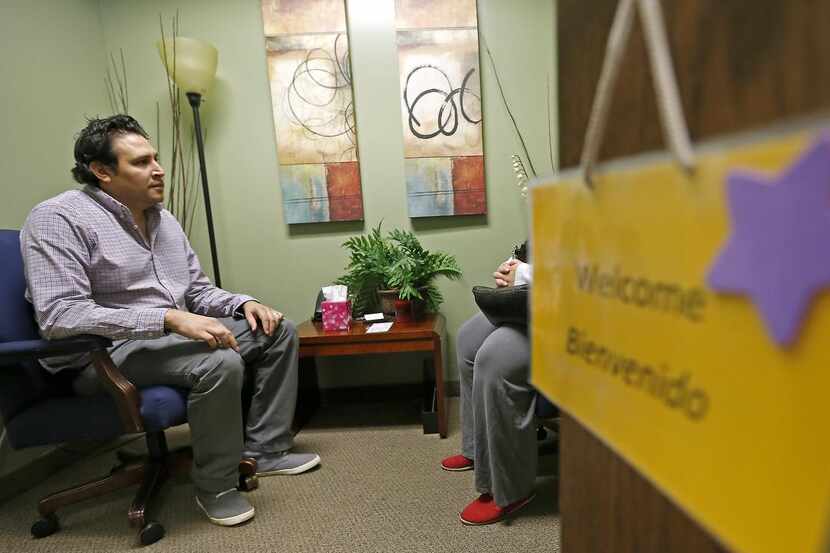 Gilbert Holguin, Clinical Director, left, talks with a client at Hope's Door.