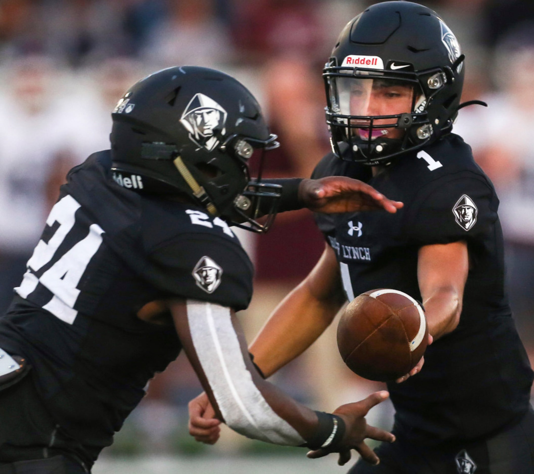 Bishop Lynch quarterback Michael Light (1) hands off to running back Darries Boyd (24)...