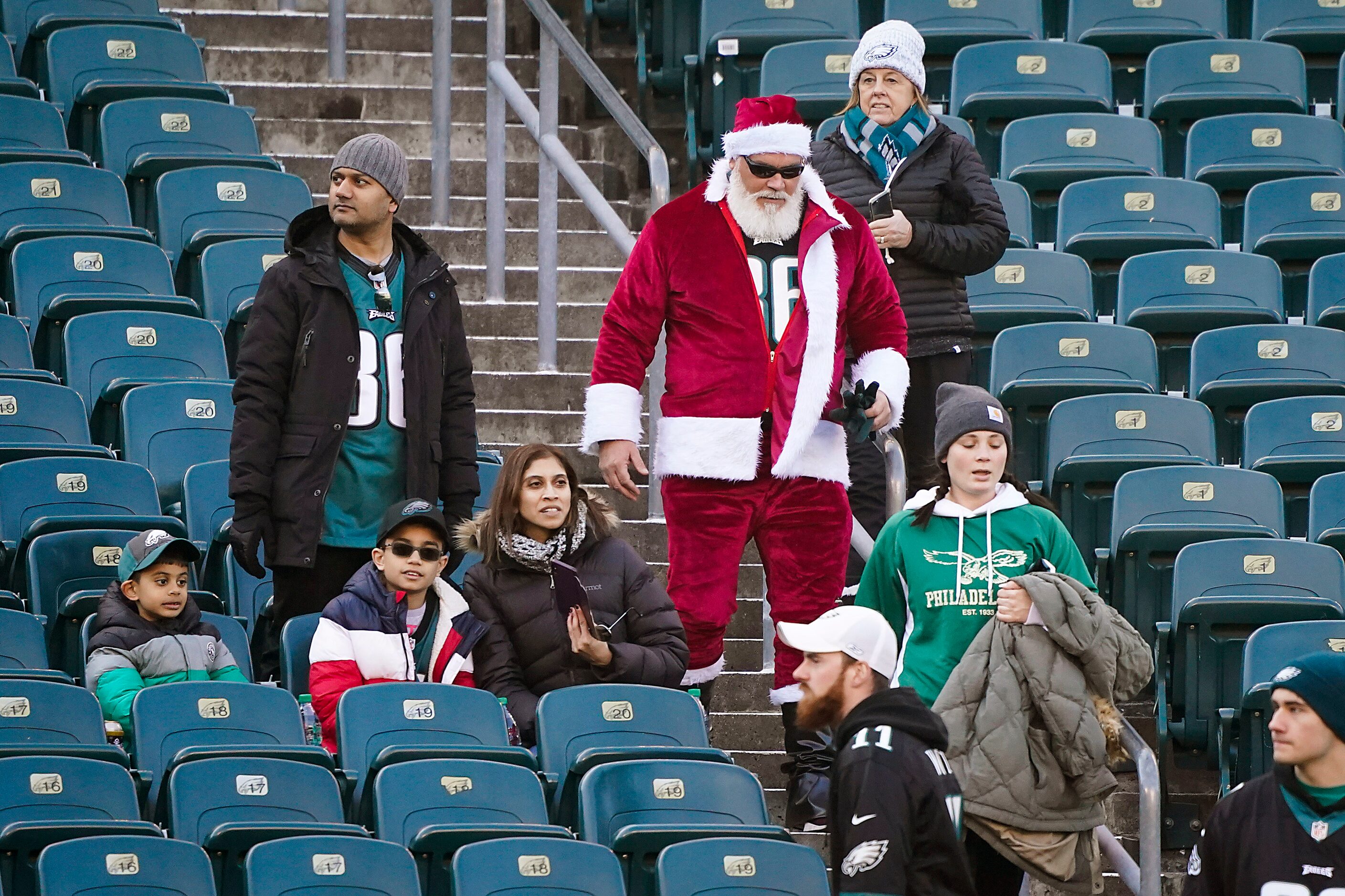 Fans, including one in a Santa suit, arrive before an NFL football game between the...