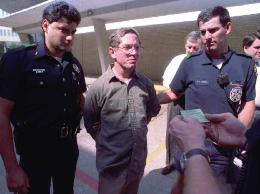 Dallas police read George Douglas Lott, center, his rights after he turned himself in to the...
