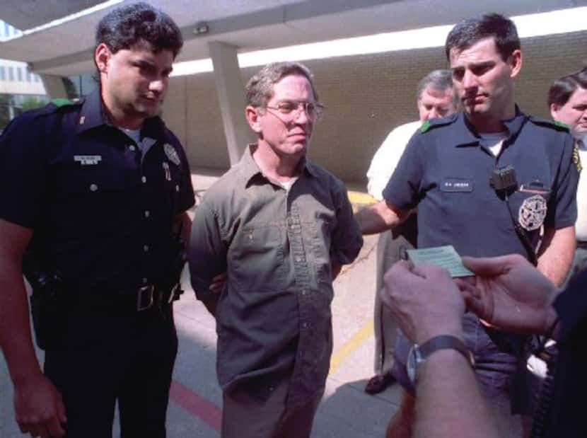 Dallas police read George Douglas Lott, center, his rights after he turned himself in to the...