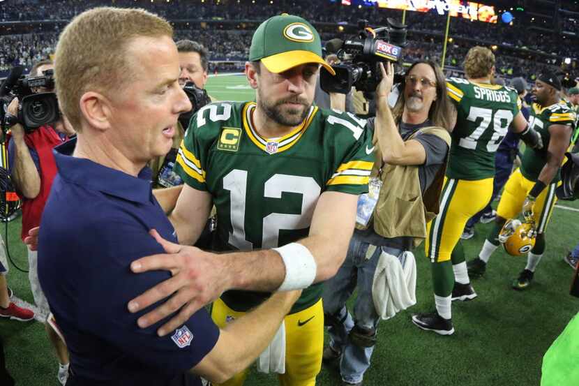 Dallas head coach Jason Garrett gets a hug from Green Bay Packers quarterback Aaron Rodgers...