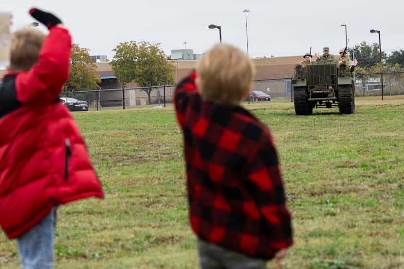 (From left) Wyatt Burke, 5, and Beckham Morgan, 4, wave as Paul Knutson with the...