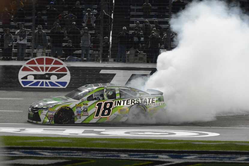 Kyle Busch (18) burns his tires after winning the NASCAR Sprint Cup Series auto race at...