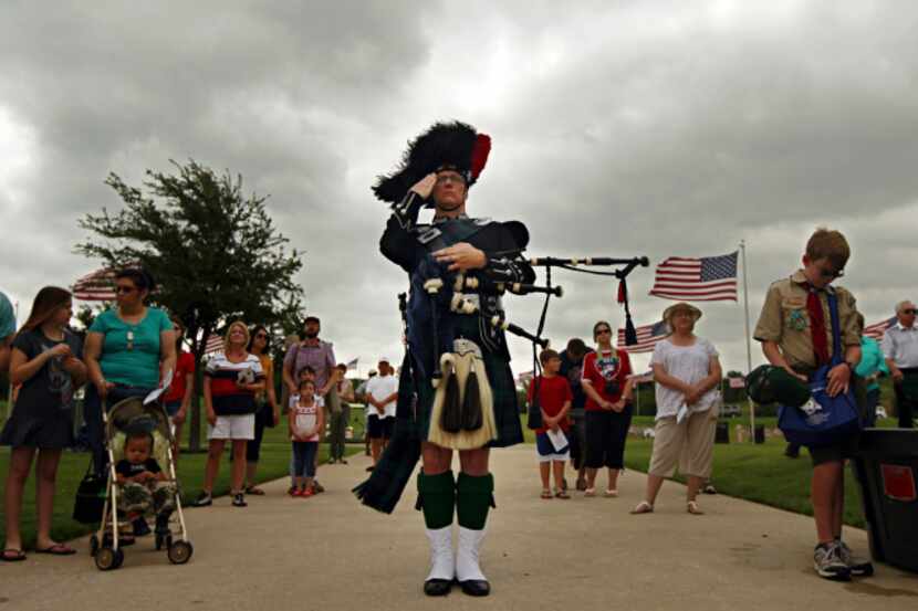 Bagpiper Steve Pruitt salutes during the National Anthem at the annual Memorial Day Ceremony...