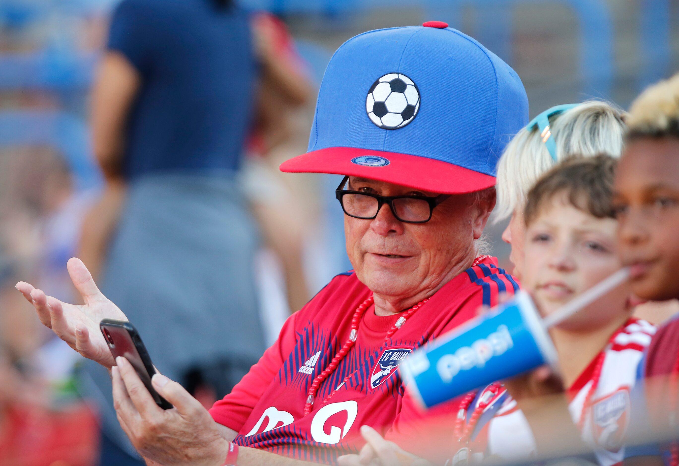 Jack Cummings of Highalnd Village, wears an oversized hat to shade from the heat before the...