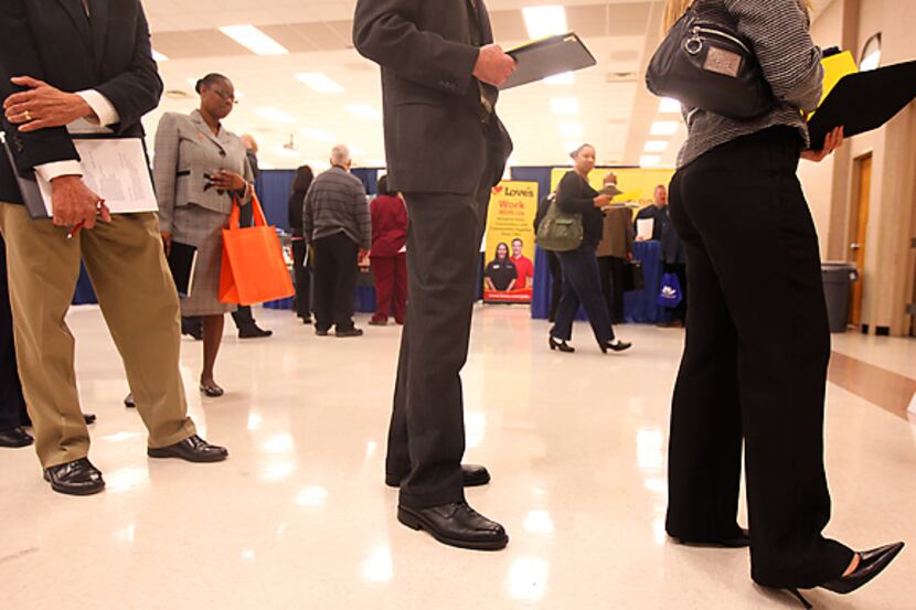 Job seekers wait to have their résumés critiqued by a professional during the Career Expo at...