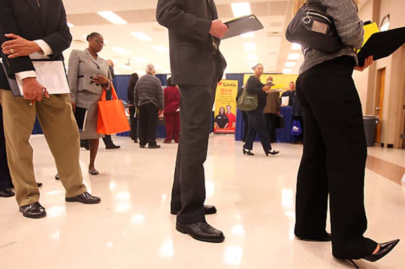 Job seekers wait to have their résumés critiqued by a professional during a Career Expo at...