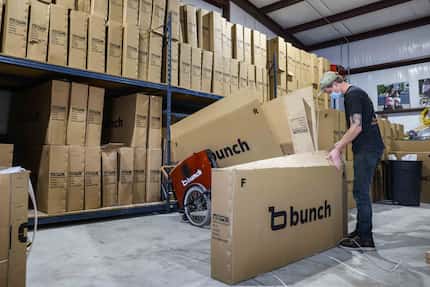 Logan Holland opens a bike box at Bunch Bikes in Denton on Wednesday, March 24, 2021. (Lola...