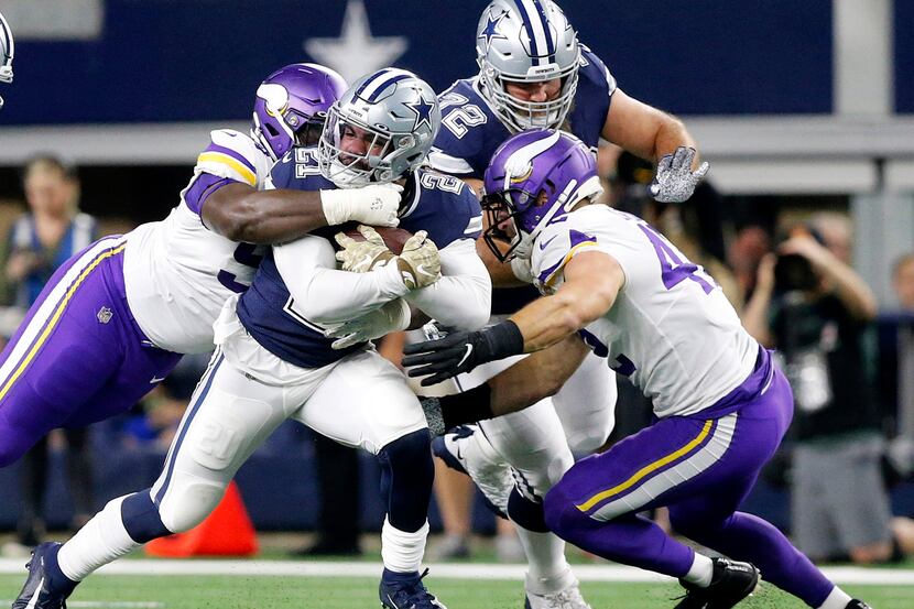 Dallas Cowboys running back Ezekiel Elliott (21) is tackled by the Minnesota Vikings defense...