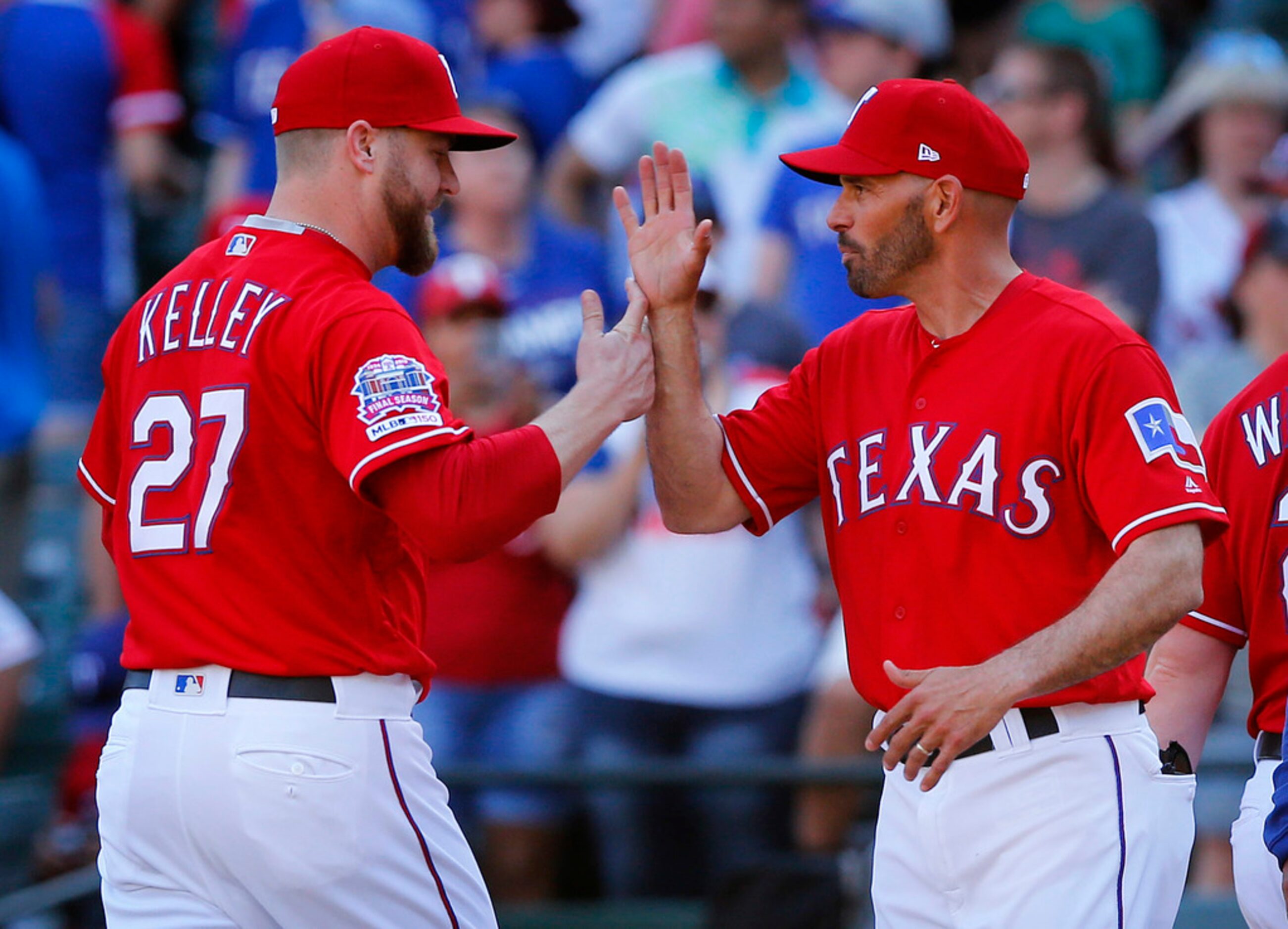 Texas Rangers relief pitcher Shawn Kelley is congratulated by manager Chris Woodward after...