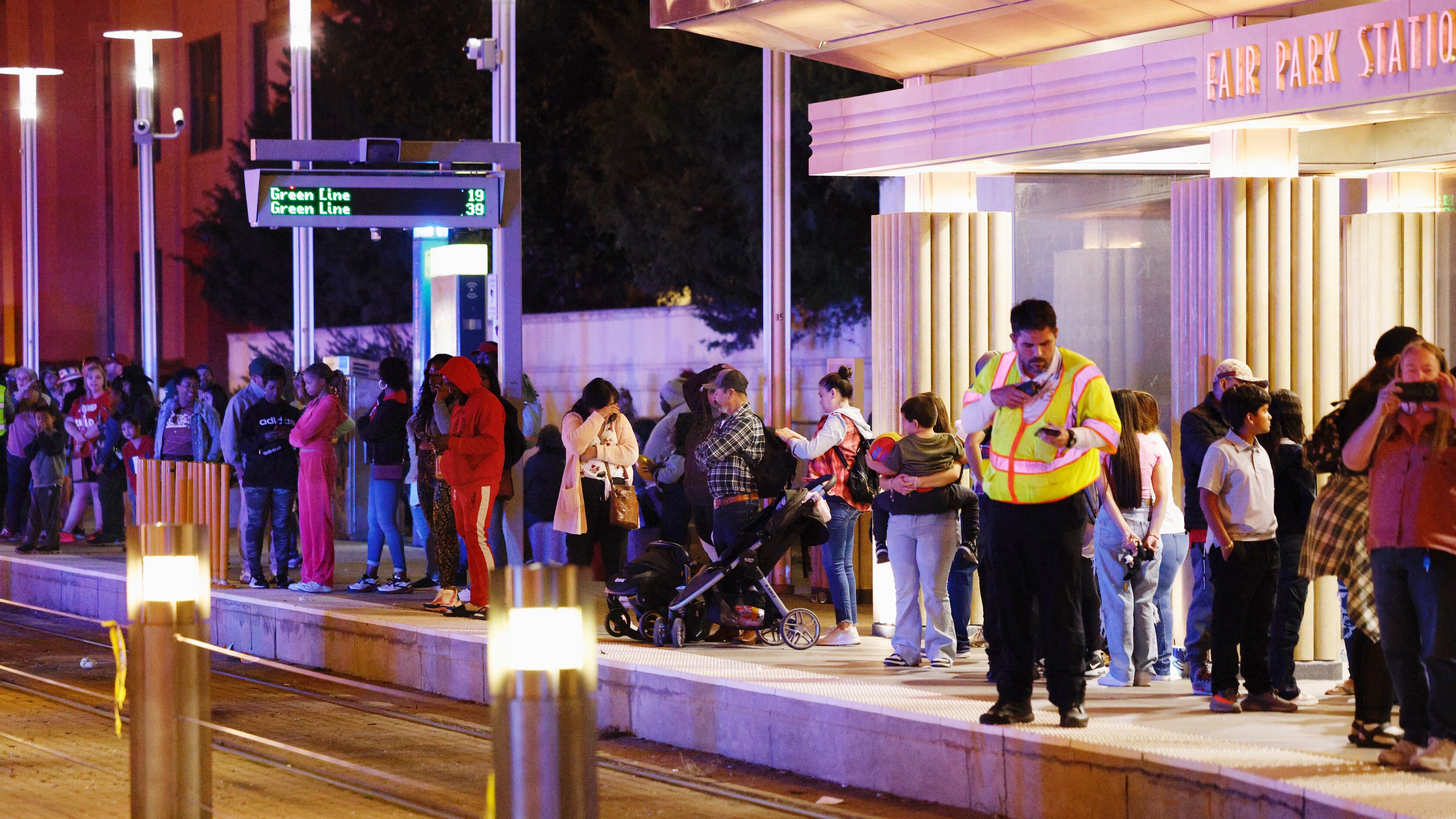 Fairgoers wait for DART Light Rail at the Fair Park Station after a shooting at the State...