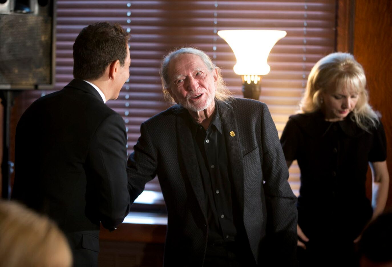 Musician Willie Nelson, center, greets Michael Feinstein, following Feinstein's performance...