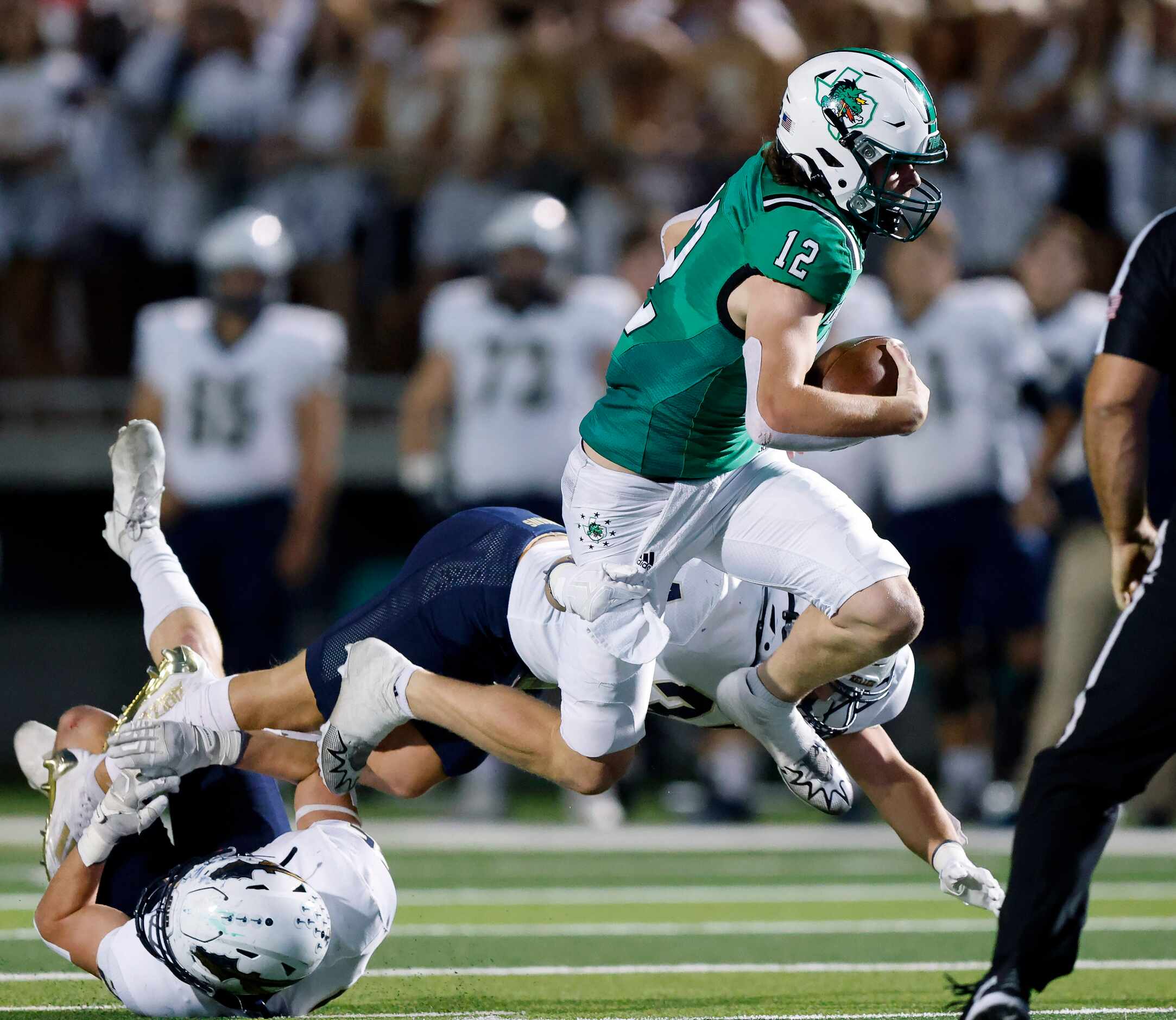 Southlake Carroll quarterback Kaden Anderson (12) runs past Keller defenders Parker Knowles...