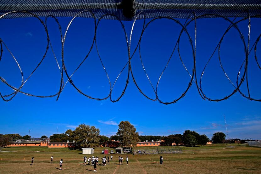 A fence topped with razor wire surrounds the football practice field at Gainesville State...