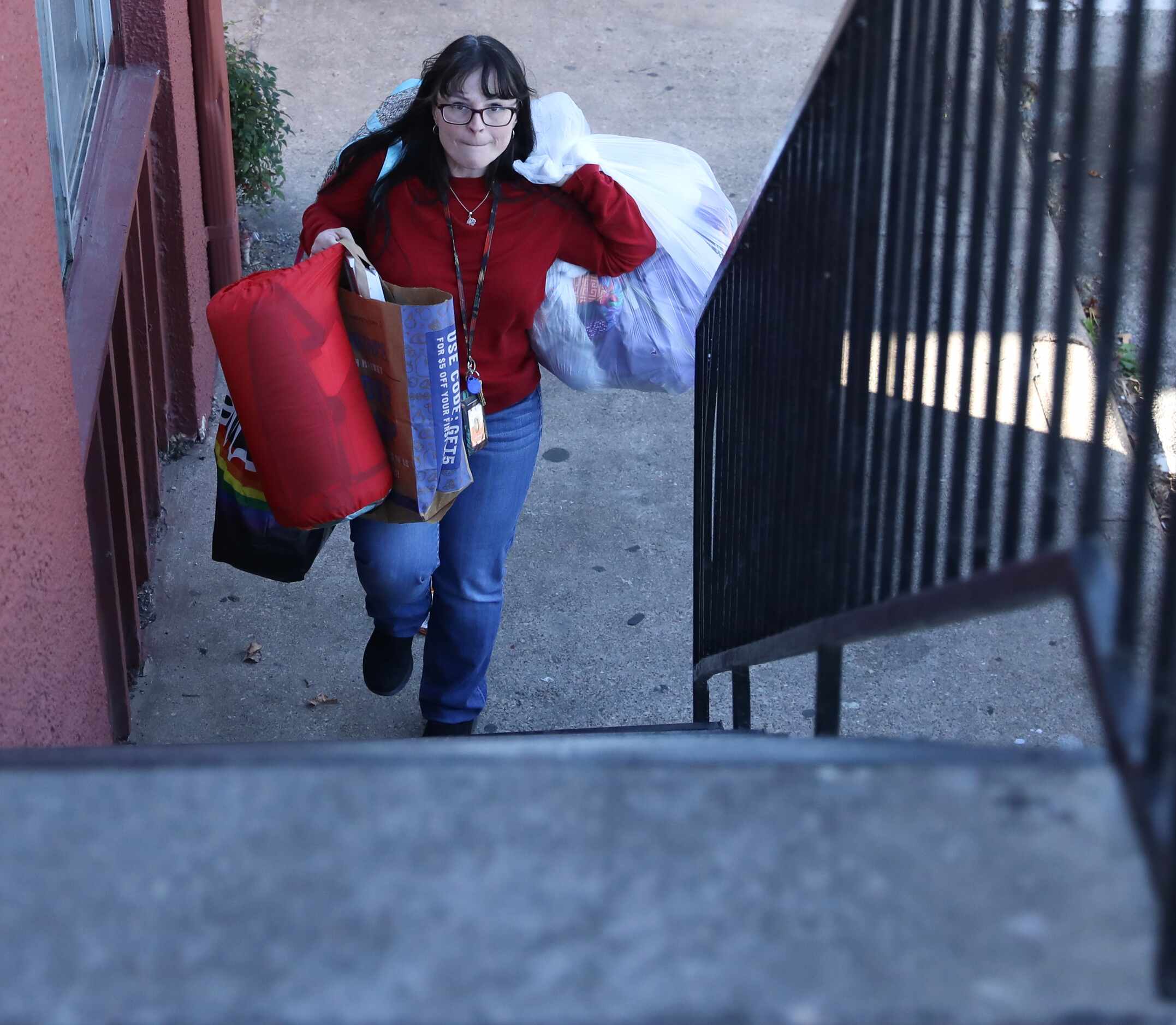 Faith Bartes, staff member at The Bridge Homeless Recovery Center, carries some of Patricia...