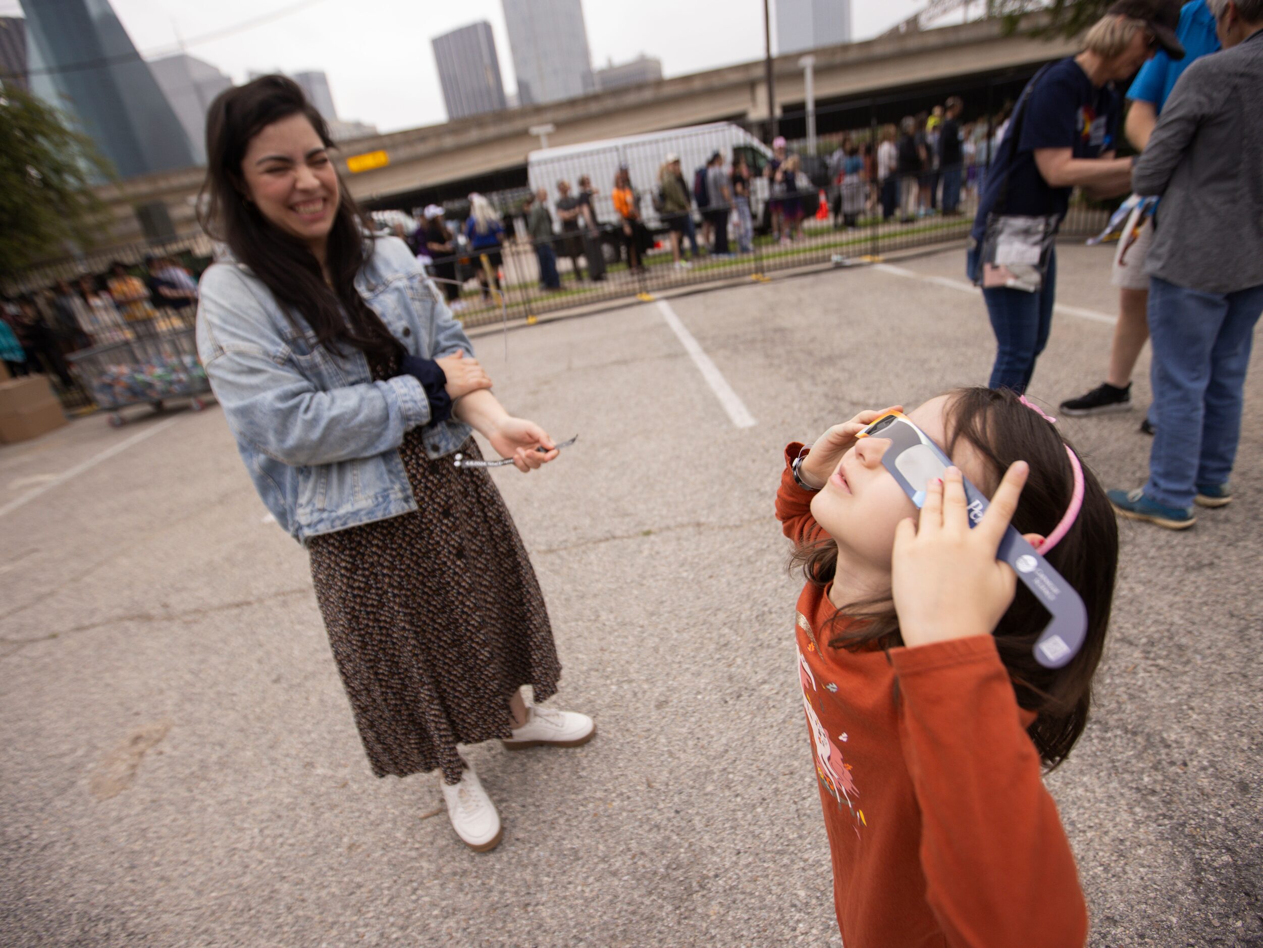 Mercedes Perez of Dallas looks as daughter Adela Smith, 5, tries on her eclipse glasses at...