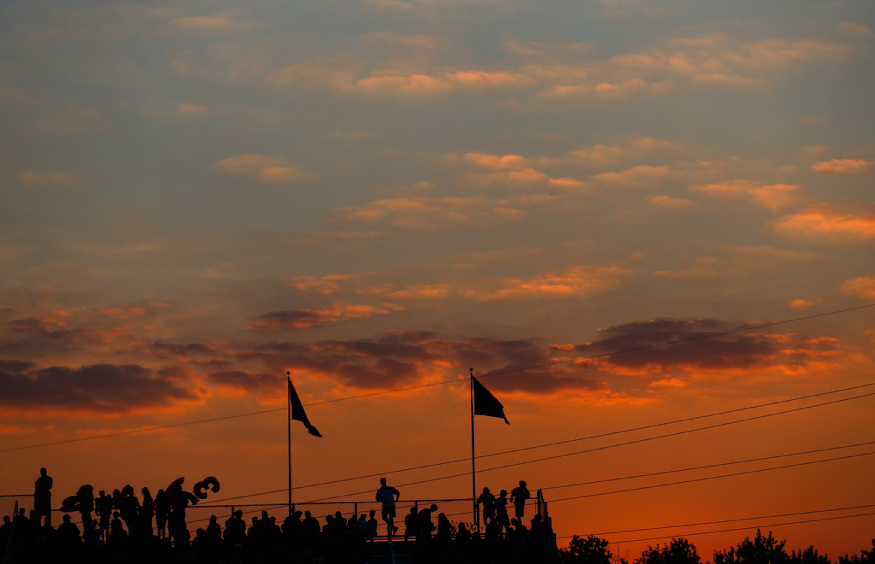 The sun sets over a high school football game between Parish Episcopal and Trinity...