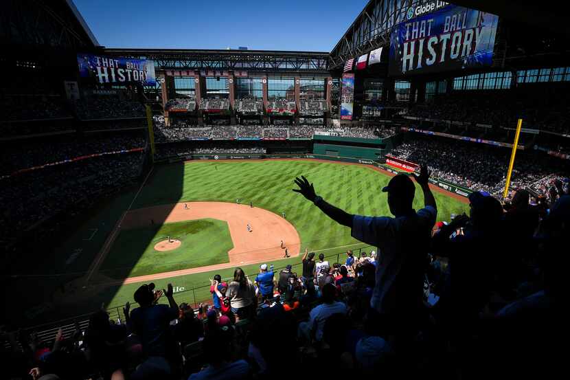 Texas Rangers fans cheer a home run by catcher Jonah Heim during the fifth inning against...