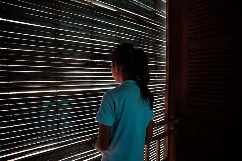 Soryia, a 14-year-old rape victim, stood by a dormitory window at the Cambodian Women's...