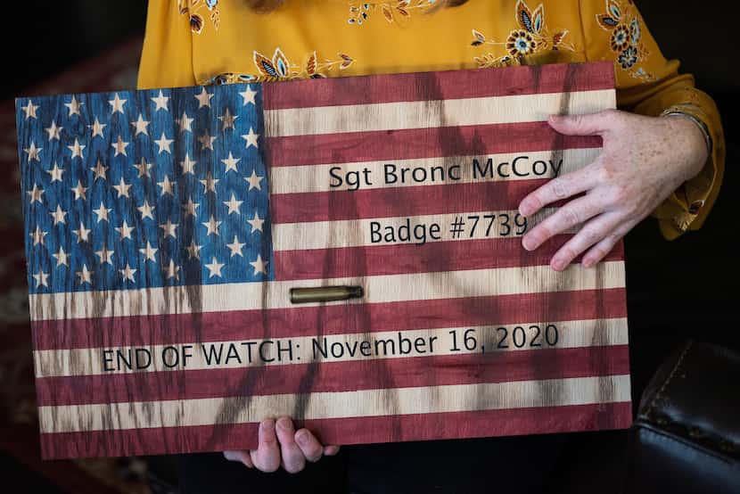 Katie McCoy holds a wooden American flag made by family to remember Sgt. Bronc "Bronco"...