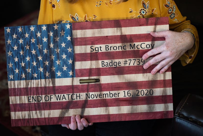 Katie McCoy holds a wooden American flag made by family to remember Sgt. Bronc "Bronco"...