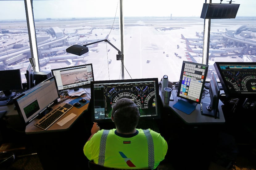 An American Airlines employee monitors screens inside the DFW Hub Control Center at...