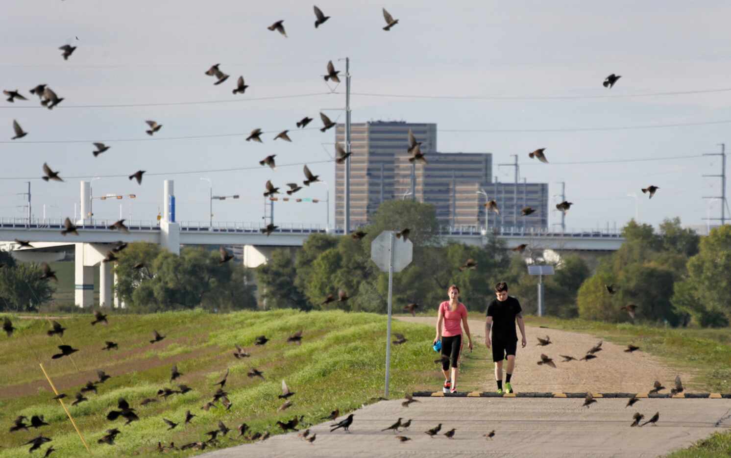 Britt Heid and David Griffin make their way along a path on the levee off of Canada Drive in...