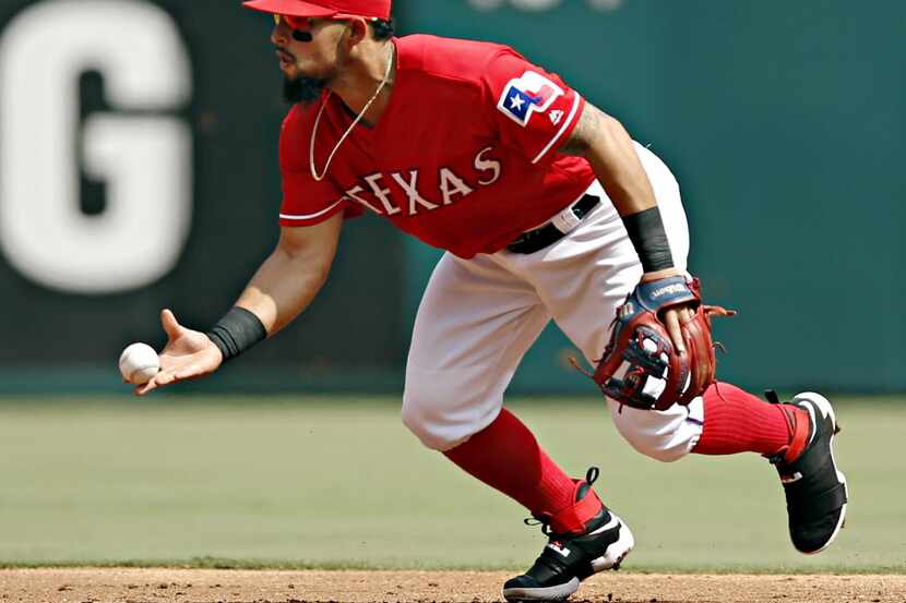 Texas Rangers second baseman Rougned Odor tosses to second base as he gets \Houston Astros...